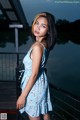 A woman in a blue dress standing on a bridge.