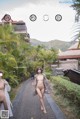 a naked woman walking down a path in front of a building